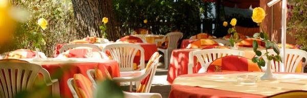 Tische im Gastgarten mit Blumendeko